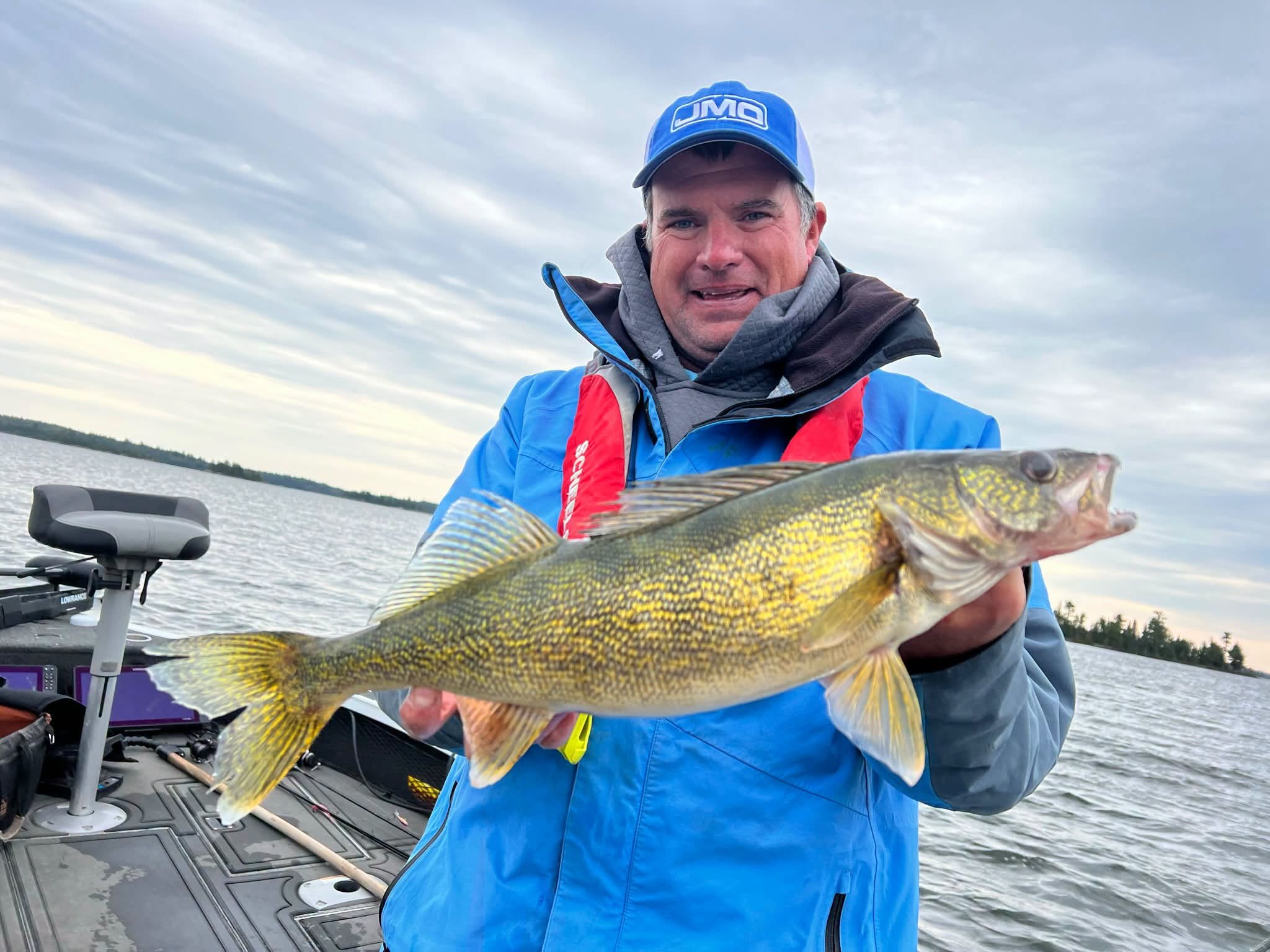 Jason Mitchell in a JMO cap holding a big fish in the boat